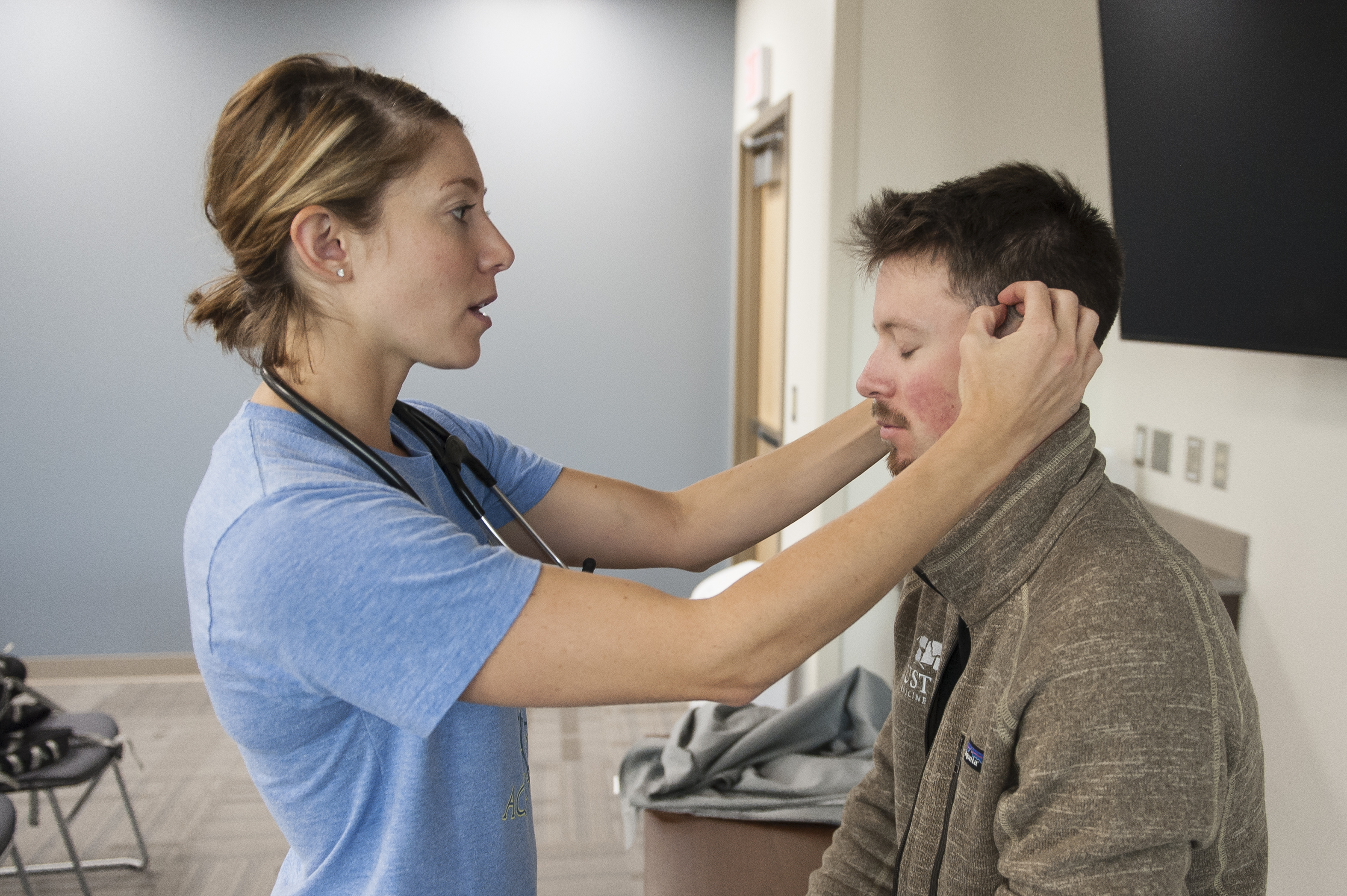 nursing student checking another student's head