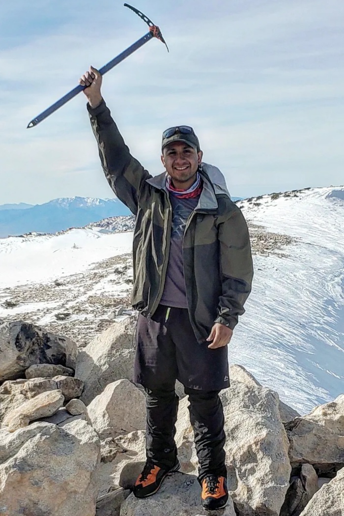 Joseph Esparza on top of a mountain with an ice axe