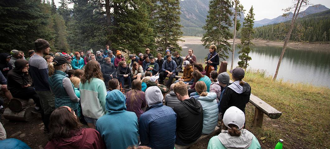 Students sitting outdoors around Ilse Marie-Lee