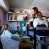 One resident lays on lofted bed in South Hedges and chats with another resident seated at desk in South Hedges double room 