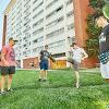 Four students play hacky sack behind South Hedges hall 