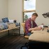 Student studying in his room at a desk alone.