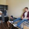 Students hanging out on top of a loft and in desk chairs in a double room.