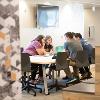 Students studying and hanging out in a common lounge area.