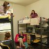 Students hanging out on top of a loft and in desk chairs in a double room.