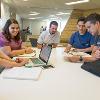 Students studying and hanging out in a common lounge area.