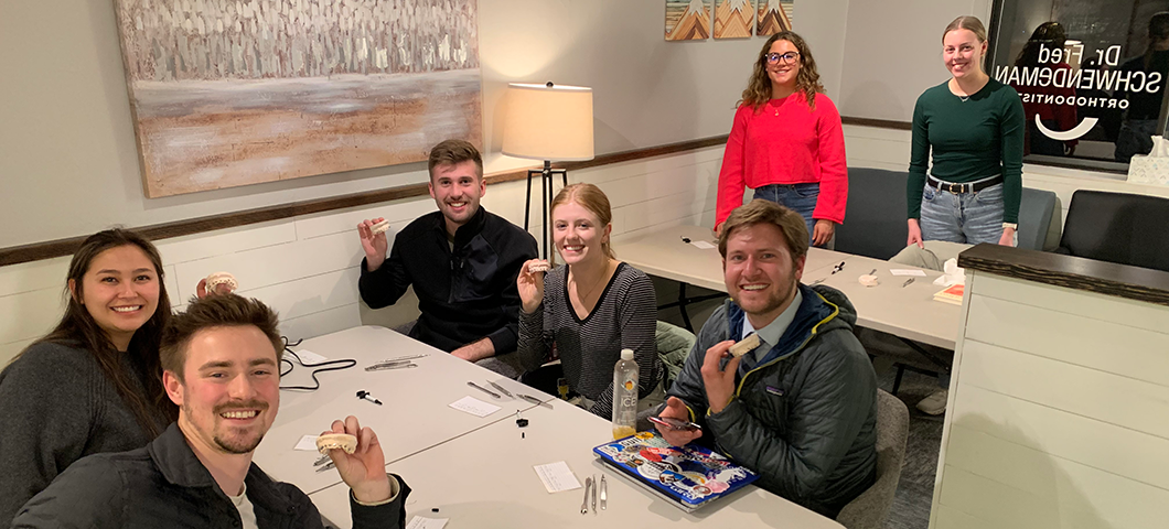 Seven HPA students posing with model teeth