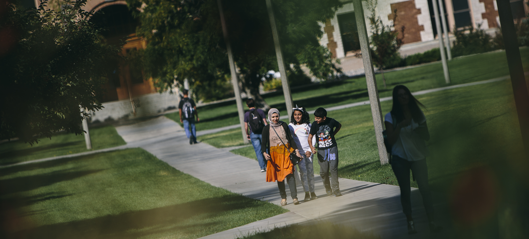 An international family walking through Romney Oval at MSU.
