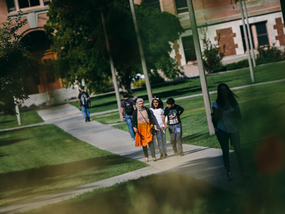 A family walking through Romney Oval at MSU.