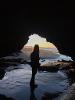 Madison under the light of the sunset in an ocean cave