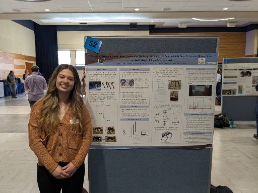 Student standing next to research poster