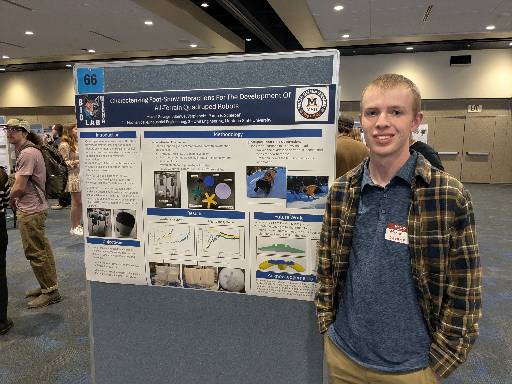 Student standing next to research poster