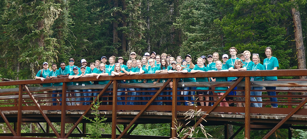 All camp participants stand on a bridge