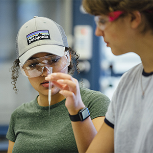 Student examines a pipette in a chemistry class