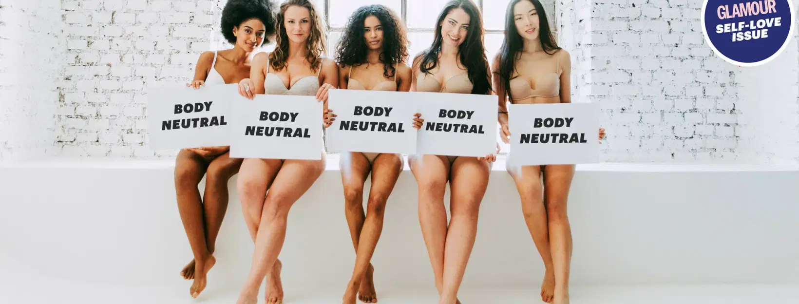 Women standing together in their underwear with signs that say Body Neutral