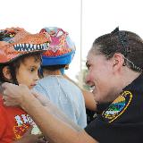 police helping child put a helmet on for safety