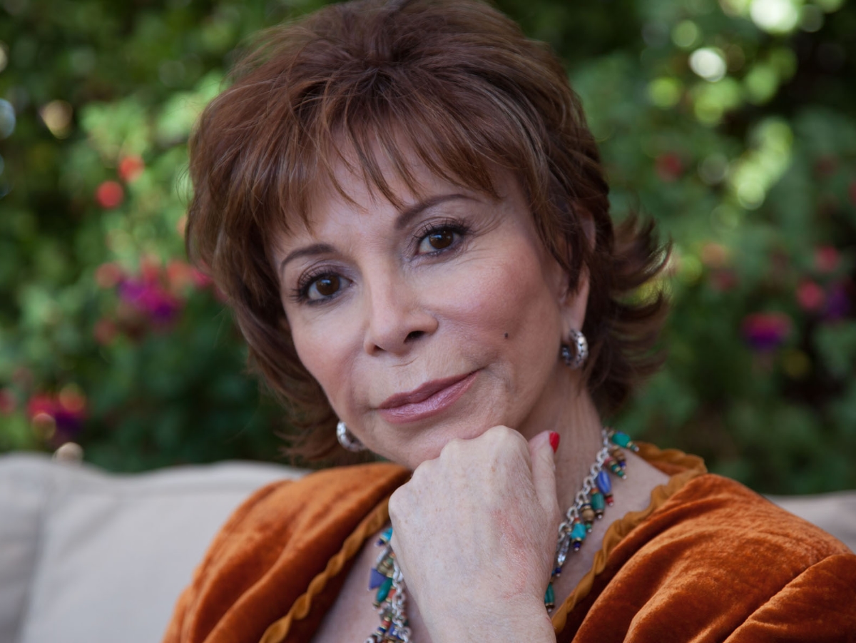 Isabel Allende, a woman in an orange blouse.
