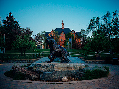 Champ statue looking up towards Montana Hall