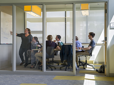 Students studying in a room with glass walls