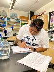 A student fills out her lab notebook