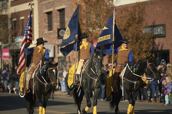 Image of people in western clothing riding horses at the MSU homecoming parade in downtown Bozeman.
